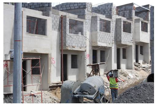 Fotograf&iacute;a de personas trabajando en construcci&oacute;n de viviendas.